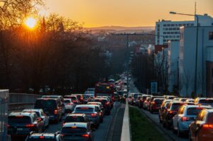 A busy city street jammed with cars and a bus during sunset, capturing urban life and rush hour traffic.